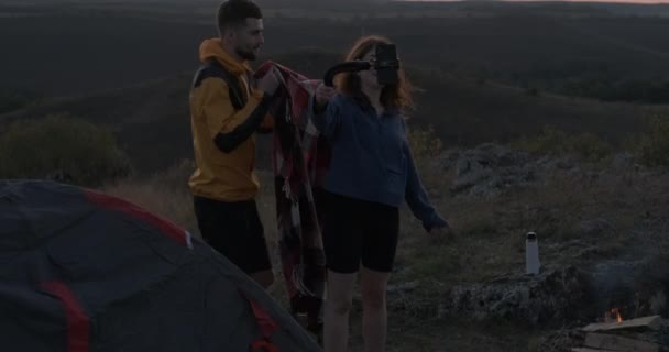 Young Traveler Couple Making Selfie on the Top of Hill at Background of Campfire and Tent in Evening — ストック動画