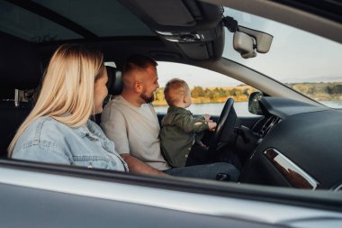 Genç Aile Yolculuğunun tadını çıkarıyor, Anne ve Baba ve Oğulları Arabada Oturuyorlar