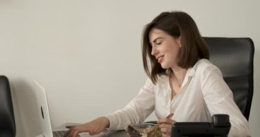 Ofiste Öğlen Yemeği Yiyen Kadın, İşyerinde Dizüstü bilgisayarın yanında çalışırken Salata Yiyen Genç Esmer Kadın