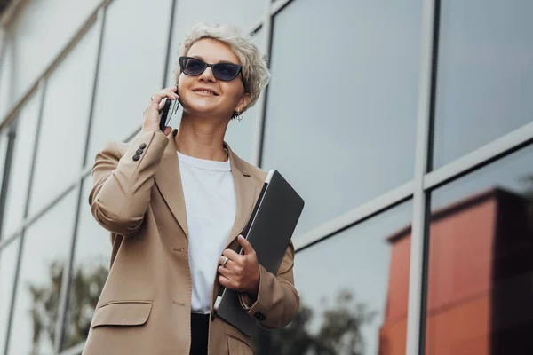Modern Business Lady Smile and Talking on Phone When Holding Laptop Outdoors