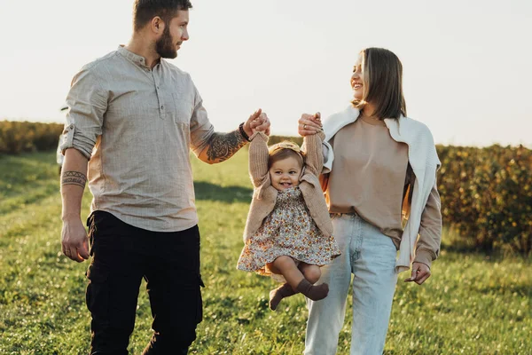 Happy Young Family Outdoors Mother Father Lifting Baby Daughter Hands — Foto de Stock