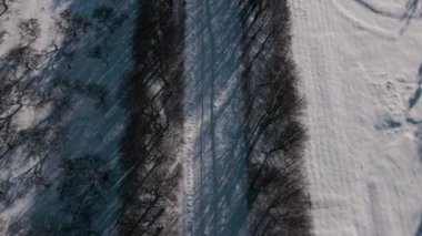 Kar Üzerindeki İHA uçağı Sunny Winter Day 'de parkı yol ile kapladı.