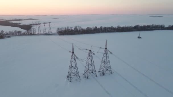 Aerial Drone View Liniach Energetycznych Nad Zaśnieżonym Polem Zachodzie Słońca — Wideo stockowe