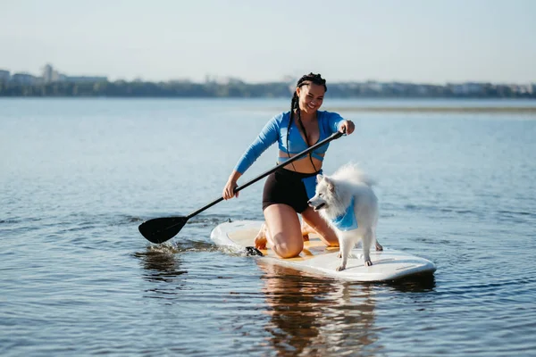 Cheerful Woman Dreadlocks Paddleboarding Her Dog Snow White Japanese Spitz — Fotografia de Stock