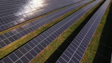 Güç çiftliği istasyonundaki güneş panellerinin havadan yakın görüntüsü, Ukrayna 'daki yenilenebilir enerji, insansız hava aracı geriye uçuyor