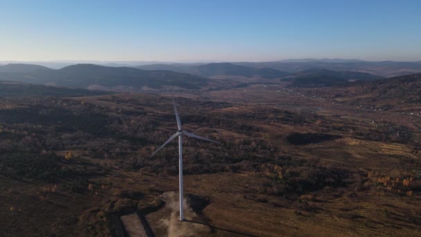 風車の空中パノラマビュー ドローンは美しい秋の風景に対して回転翼を持つ風力タービンを飛ぶ — ストック動画