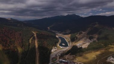 Bukovel tatil köyünün hava manzarası, Ukrayna Karpatları sonbaharda alçak bulutlar ve dağlar arasında göl manzarası