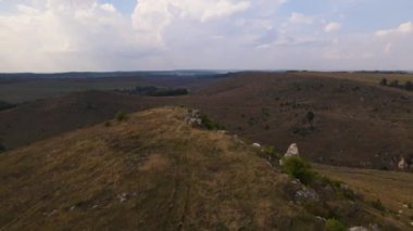 Kayalık tepedeki hava manzarası, insansız hava aracı taşlı arazinin üzerinden hızla geçiyor.