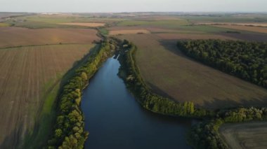 Nehirdeki hava panoramik görüntüsü tarımsal alanlar arasında, insansız hava aracı ileri uçuyor