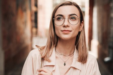 Gözlüklü, kendine güvenen zarif bir kadının yakın portresi. Şehirde gözlüklü, şık sarışın bir kız.