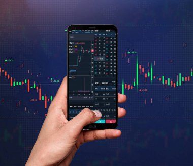 Ticaret konsepti. İş ellerinin telefonu tutması ve akıllı telefondan ekrana dokunması, borsa geçmişi bulanıklaştırıyor.