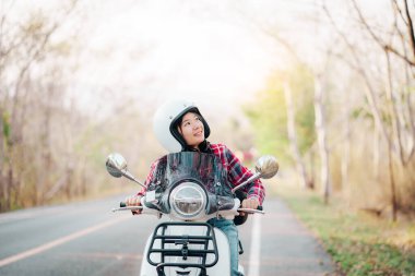 Motosiklet süren genç bir kız. Motosikletle seyahat ediyor. Tatilde kırsalda yavaş bir hayat sürüyor..