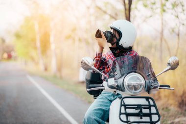 Motosiklet süren genç bir kız. Motosikletle seyahat ediyor. Tatilde kırsalda yavaş bir hayat sürüyor..