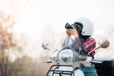 Motosiklet süren genç bir kız. Motosikletle seyahat ediyor. Tatilde kırsalda yavaş bir hayat sürüyor..