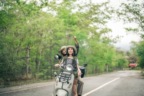 道路上のモータースクーターに乗る美しい女性 休暇中に田舎で友人の遅い生活を持つスクーターで旅行 — ストック写真