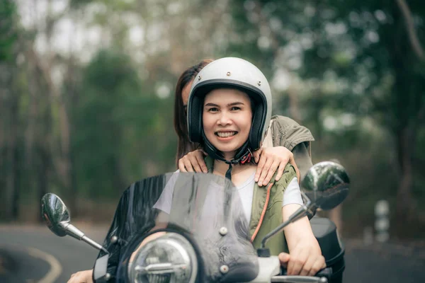 道路上のモータースクーターに乗る美しい女性 休暇中に田舎で友人の遅い生活を持つスクーターで旅行 — ストック写真