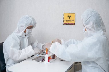 Tıbbi koruma giysisi araştırmacılarından oluşan bir ekip laboratuarda Covid-19, Coronavirus 'un antiviral ilacını icat edip araştırıyor.