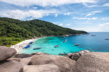 Similan Adası 'nın manzarası. Tayland' ın Phang Nga kentindeki bir plajda seyahat eden turistler ve sürat teknesi.
