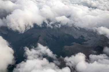 Dağ sırasındaki beyaz bulutlu uçaktan görünüm 