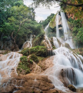 Ulusal park, Kanchanaburi, Tayland 'daki tropikal yağmur ormanlarındaki doğal taşlardan akan suyla Erawan şelalesi 7. kat.