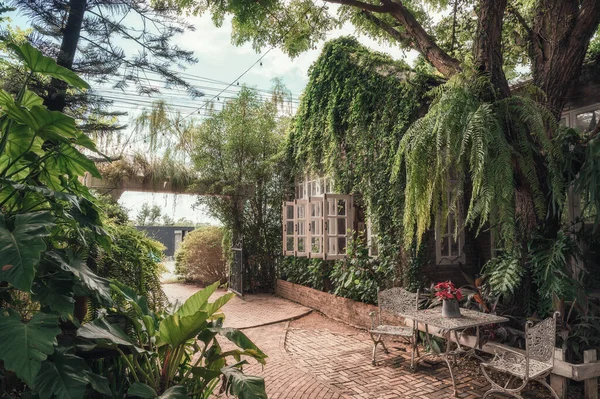 装飾庭園と裏庭のパティオでの座席を持つレンガ造りのコテージ — ストック写真