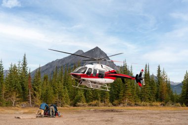 Alp helikopteri Banff Ulusal Parkı, Canmore, Kanada 'ya uçuyor ve iniyor.