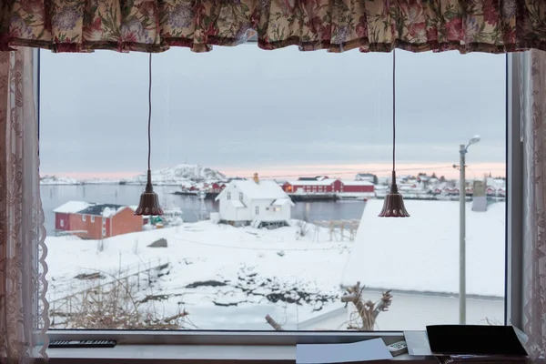 雪の景色は カーテンとランプで窓から海岸線の村を覆いました — ストック写真