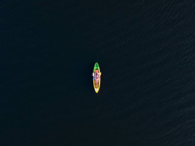 Kanodaki neşeli Asyalı çiftin gölde yüzüşünün üst görüntüsü.