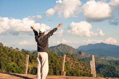 Tayland, Chiang Mai 'de dağ zirvesi olan ahşap balkonda yükselen Asyalı kadının neşeli arkası.