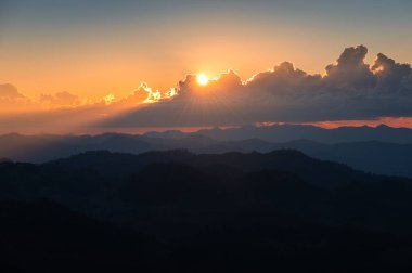 Ulusal parktaki tropikal yağmur ormanlarında, bulutların üzerinde parlayan gün batımı. Doi Kham Fah, Wiang Haeng, Chiang Mai, Tayland