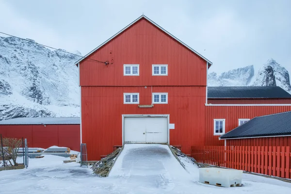 Reine镇冬季背景下的大型红色仓库和山脉 — 图库照片