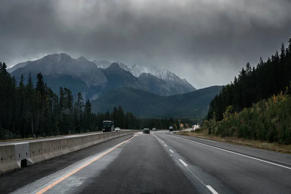 Carro Dirigindo Estrada Com Montanhas Rochosas Céu Temperamental Dia Nublado — Fotografia de Stock