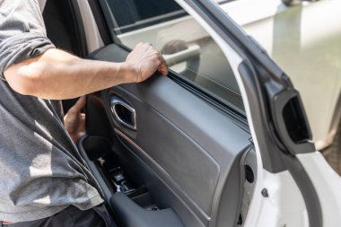 Tamirci, garajdaki hasarı kontrol etmek için takozların açıldığı araç kapısını kullanıyor.