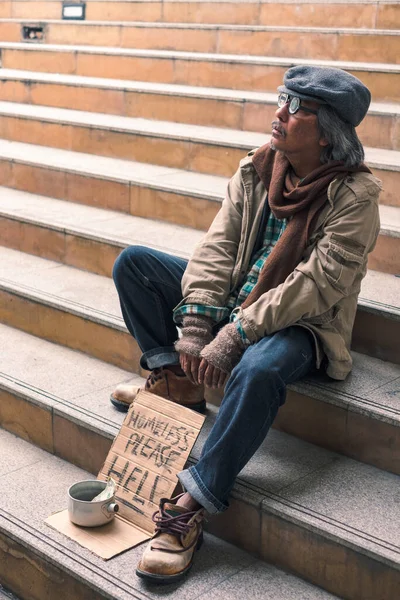 肮脏的无家可归的人坐着 站在楼梯上 手里拿着美元现金 — 图库照片