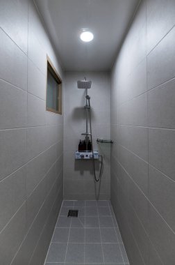 Dar banyonun içinde duş suyu ısıtıcısı ve pansiyonda bej seramik var.