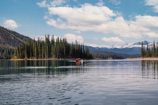 Güneşli bir günde Kanada 'daki Jasper Ulusal Parkı' nda Maligne Gölü 'nde kano yapan turistler. Boş zaman aktivitesi, eğlence arayışı.