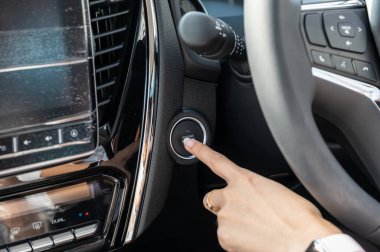 Modern otomobilde motoru iten kadın parmağı bottonu çalıştırıyor