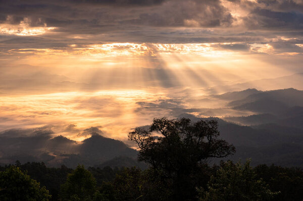 Beautiful dramatic sunrise shining on mountain with foggy in the valley at national park. Doi Dam, Wiang Haeng, Chiang Mai, Thailand
