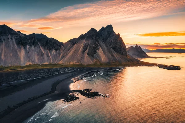 Aerial view of beautiful sunrise over Vestrahorn mountain and black sand beach in Atlantic ocean at Stokksnes on the southeastern at Iceland