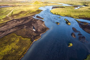 Above of four wheel drive vehicle parked by the big river crossing in the evening on remote rural at Icelandic Highlands
