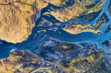 Top view of abstract blue glacier rivers pattern flowing through volcanic moss field in Icelandic highlands on summer