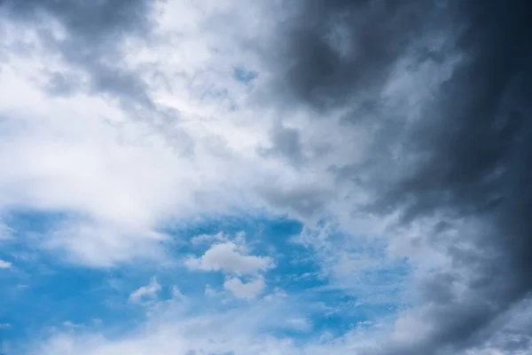 White cloud and storm cloud on blue sky in daylight before rain storm