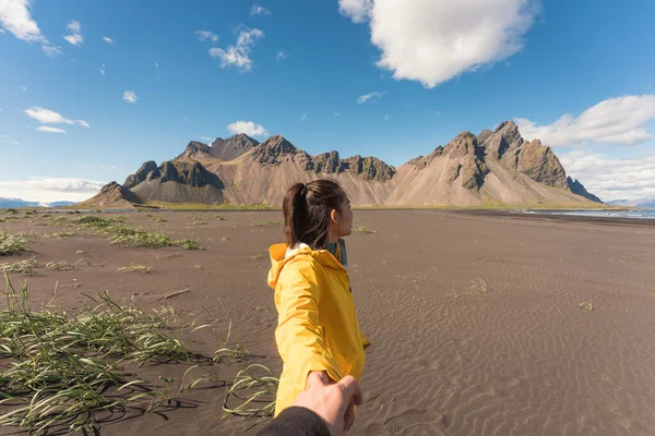若いですアジアの女性で黄色のジャケット保持手でボーイフレンドとビーチでVestrahorn山でバイキング村でStoknes半島で南東アイスランド — ストック写真