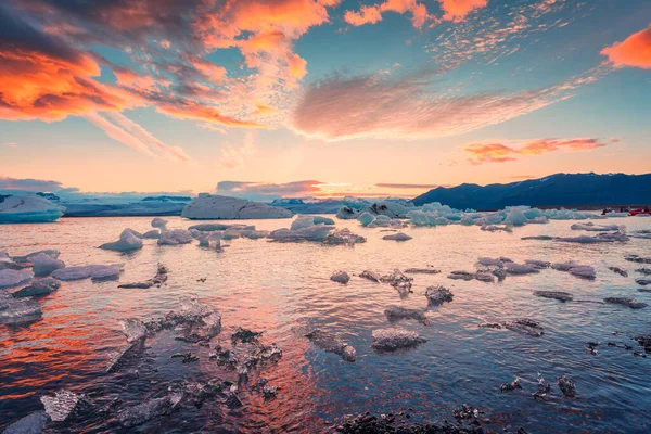 アイスランドのヴァトナヨークトル国立公園ジョクルサロン氷河ラグーンに浮かぶ氷山と氷の上の美しい夕日 — ストック写真