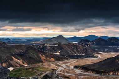 İzlanda Dağları 'ndaki volkanik dağın dramatik manzarası ve İzlanda Landmannalaugar, İzlanda' da kasvetli bir günde kasvetli gökyüzü ile nehir geçişi.
