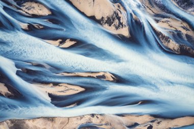 İzlanda 'nın dağlık bölgelerinde yaz mevsiminde eriyen buzul nehirlerinin hayali insansız hava aracı görüntüsü