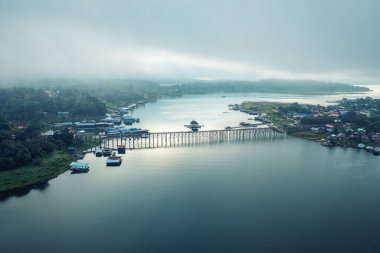 Geleneksel Mon köyünün Sangkhlaburi, Kanchanaburi, Tayland 'daki barajda sabah sisli ve ahşap Mon köprüsü manzarası.