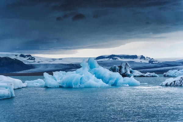 概要アイスランドのヴァトナヨークトル国立公園のジョクルサロン氷河ラグーンに浮かぶ青い氷山 気候変動 地球温暖化の概念 — ストック写真