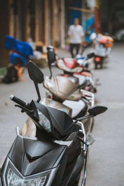 Çin 'in Shaanxi Eyaleti Xian kasabasında bir caddeye park etmiş küçük motosiklet ve scooterlar.