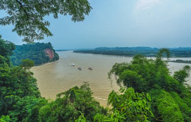 Çin 'in Sichuan eyaletinin güney kesimindeki dev Budda' nın üzerinde yer alan manzaralı gözcüden görüldüğü üzere, Leshan 'daki Min Nehri ve Dadu Nehri' nde turistlerle gezen üç tekne görülüyor.